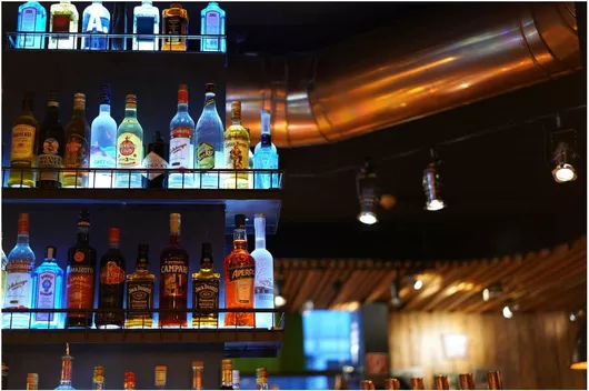 Πίνακας Illuminated Bottles on a Bar Shelf Φωτιζόμενα μπουκάλια σε ράφι μπαρ 80x50cm